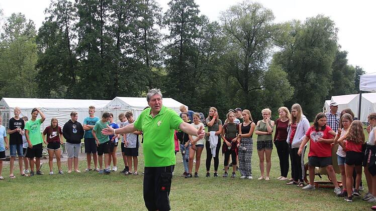 Rund 80 Kinder und Jugendliche aus Bayern, Thüringen und Kärnten nehmen derzeit am internationalen Jugend- und Freizeitcamp "Grenzenlos" in der Freizeitanlage am neuen Naturbad in Autenhausen teil. Verantwortlich für das Freizeitprogramm zeichnet Jürgen Forscht, der am Donnerstag Teilnehmer um sich versammelte, um ihnen die anstehenden Termine zu erläutern. Foto: Bettina Knauth