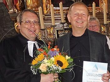 Mit Blumen dankte (von links) Pfarrer Christoph Teille dem Organisten Eduard Schwarz.  Foto: Dieter Wolf