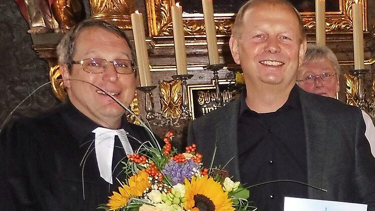 Mit Blumen dankte (von links) Pfarrer Christoph Teille dem Organisten Eduard Schwarz.  Foto: Dieter Wolf