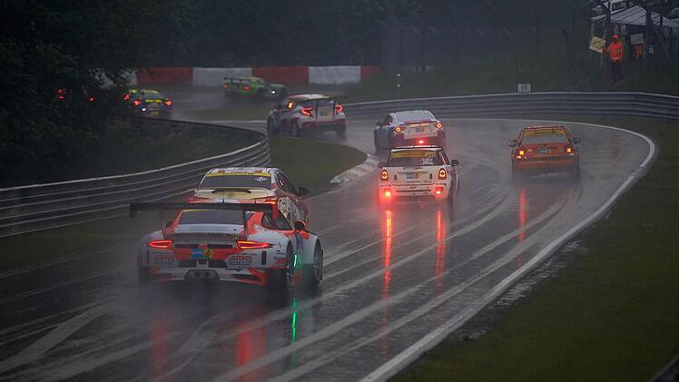 Der 230 PS-starke Mini des Nexen-Tire-Teams (r.) um Steven Fürsch passiert bei strömenden Regen den Abschnitt "Hatzenbach".  Foto: Frey/dpa