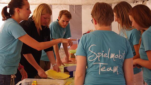 Julia Lang (l.) und Lisa Gratzke (2. v. l.) bereiten mit ihrem Spielmobil-Team das Programm f&uuml;r die Kinder vor. Foto: Marco Mei&szlig;ner