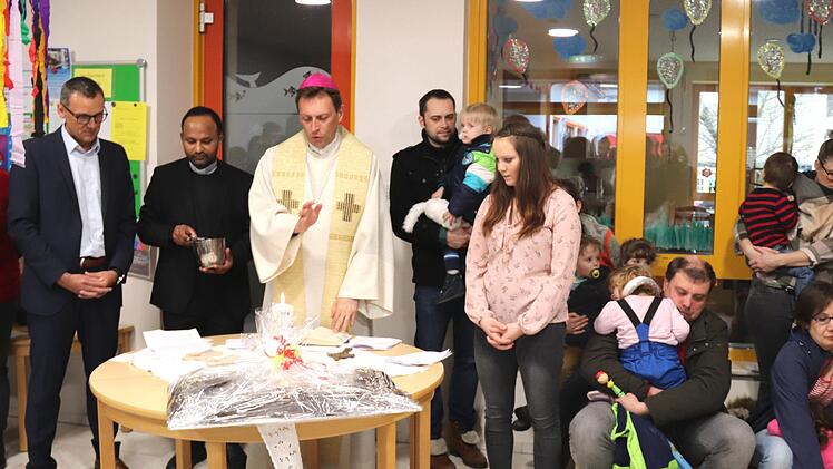 Der Weihbischof segnet die Kreuze für die neuen Räume.