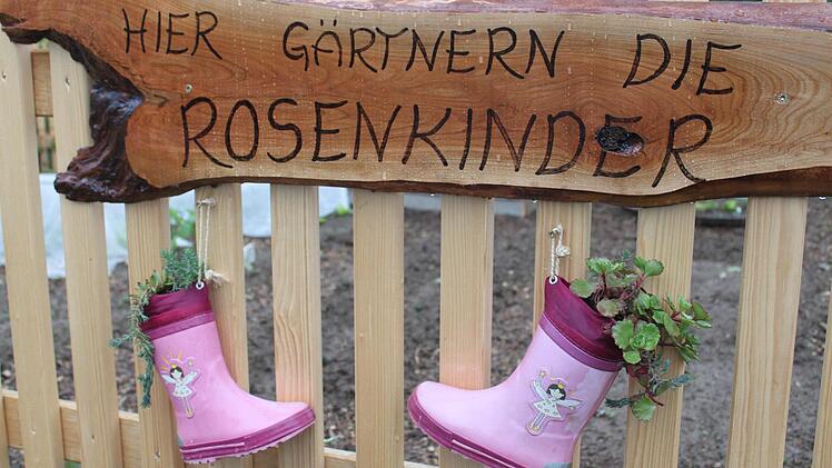 Die "Rosenkinder" zeigen auf bezaubernde Weise Flagge: Am Gartenzaun baumeln zwei bepflanzte Gummistiefelchen. Fotos: Häggberg
