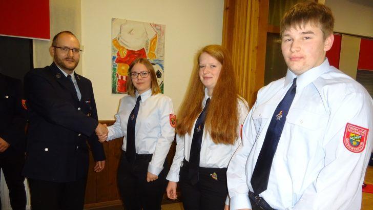 Kommandant Michael Geßner (links) nahm per Handschlag Julia Ziegler, Daniela Geßner und Steffen Geßner (von links) in den aktiven Feuerwehrdienst auf. Foto: Anton Then