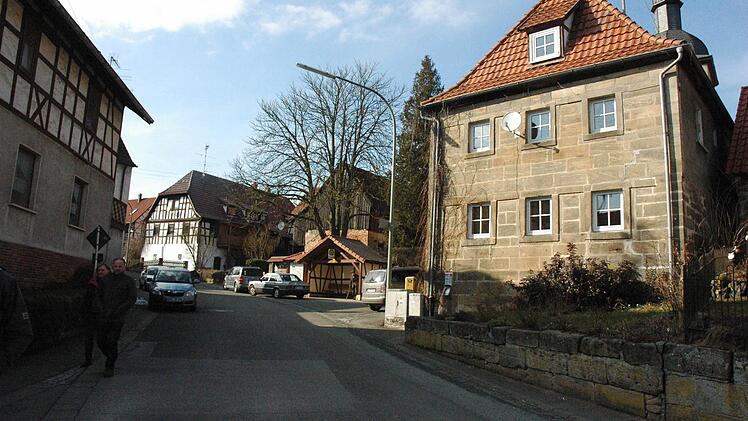 Die Sandsteinmauer vor der alten Schule in Hafenpreppach (rechts) soll als Trockenmauer gestaltet und zurückgesetzt werden, damit der Gehweg etwas breiter wird.
