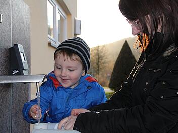 Emmeran holt mit seiner Mutter Izabella Hofweber Wasser von der Abfüllanlage. Kaum ist der Kanister voll, werden die beiden kontrolliert. Foto: Ulrike Müller