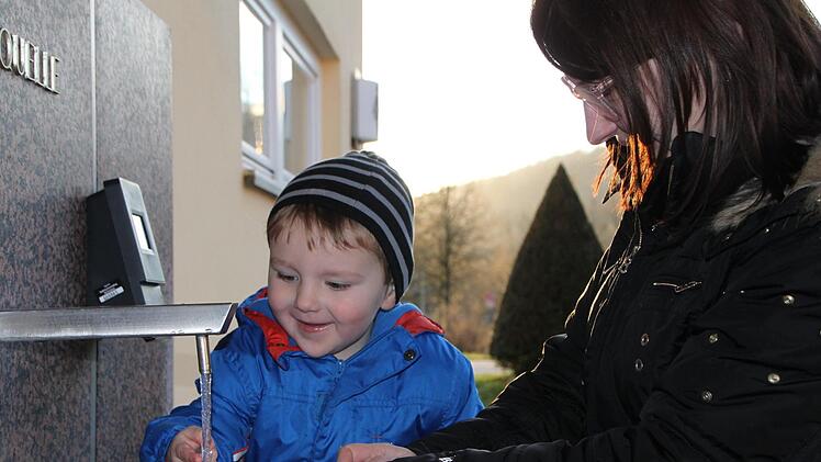 Emmeran holt mit seiner Mutter Izabella Hofweber Wasser von der Abfüllanlage. Kaum ist der Kanister voll, werden die beiden kontrolliert. Foto: Ulrike Müller