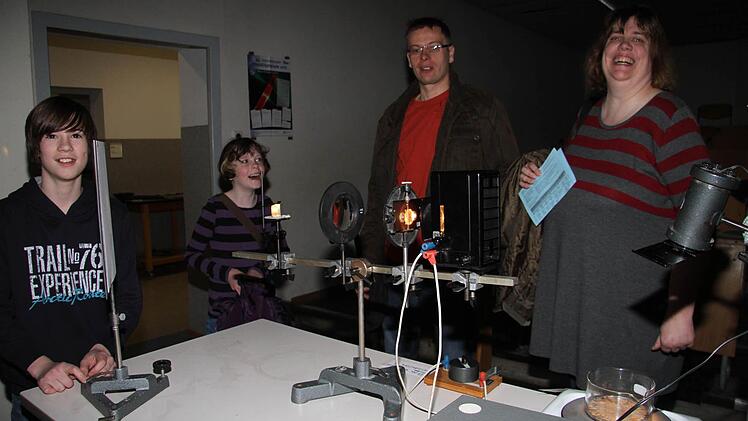 Birgit und Peter Anders (von rechts) informieren sich mit Tochter Dorothee über das Angebot des Gymnasiums. Jan-Felix Spitzenpfeil (links) zeigt, was in der Astronomie so passiert.