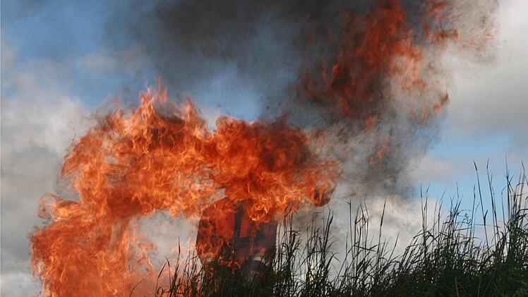 Die Stichflamme, gut bewacht von einem Feuerwehrmann, symbolisiert den Heiligen Geist.