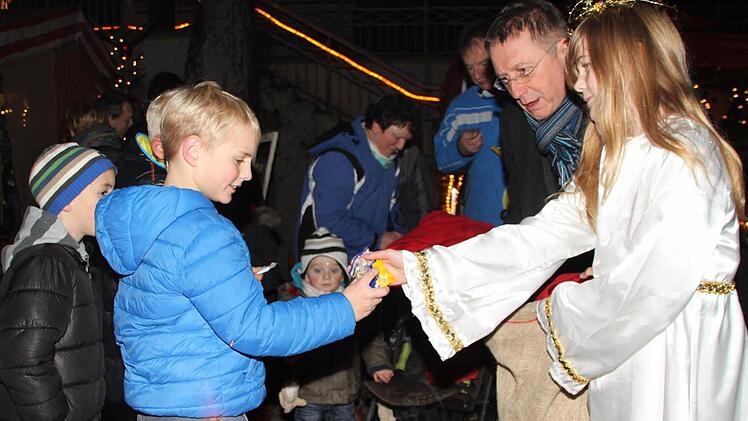 "Christkind" Franka Märkl und OB Henry Schramm beschenken die Kinder beim Kulmbacher Adventsmarkt. Foto: Stephan Tiroch