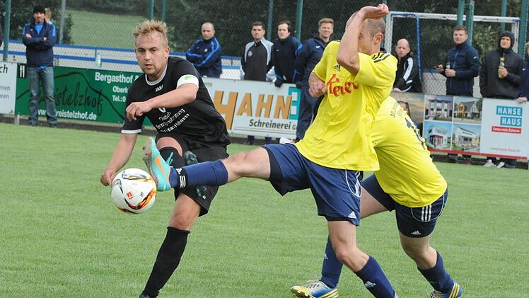 Alles in die Waagschale geworfen: Tim Goble von der SG Oberleichtersbach/Modlos bringt das lange Bein ins Spiel beim Schuss des Stangenrothers Enrico Rauch,  Foto: Hopf