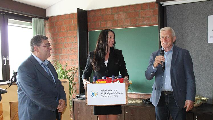 Fritz Kroder (l.) erhält ein Geschenk von Vertretern der Ehrenamtlichen. Foto: Carmen Schwind