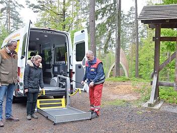 Michael Kempf (rechts) zeigt Friederike Reuß und Heinrich Graf zu Ortenburg, wie der Lift funktioniert, der Rollstuhlfahrer problemlos ins Fahrzeug des ASB hebt, das sie zum Ruhewald bringt. Foto: Rainer Lutz