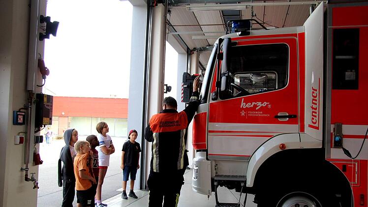 Kommandant Rainer Weber erklärt den Kindern, was die Feuerwehrzeuge leisten können. Fotos: Richard Sänger