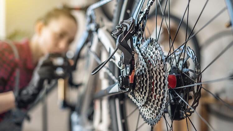 Woman is performing maintenance on mountain bike. Concept of fixing and preparing the bicycle for the new season