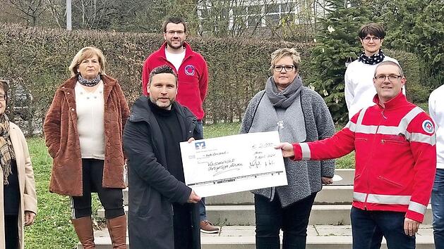 Martin Finzel, Bürgermeister und Vereinsvorsitzender, übergibt die Spende an Matthias Reg von der Wasserwacht.