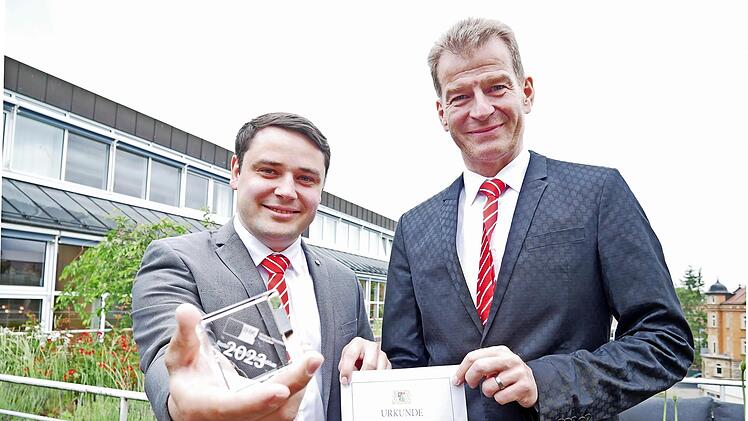 Jonas Wehner (links) von der Sparkasse Bad Kissingen hat 2023 als bester Bankfachwirt Mainfrankens bei den IHK-Weiterbildungsprüfungen abgeschlossen und wurde dafür ausgezeichnet. Sparkassenvorstand Michael Rendl gratuliert.