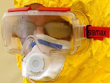 Ein freiwilliger Helfer steckt im Schutzanzug. Er lässt sich an der Klinik in Würzburg für die Ebola-Hilfe schulen. Foto: epd