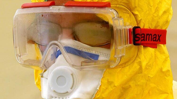 Ein freiwilliger Helfer steckt im Schutzanzug. Er lässt sich an der Klinik in Würzburg für die Ebola-Hilfe schulen. Foto: epd