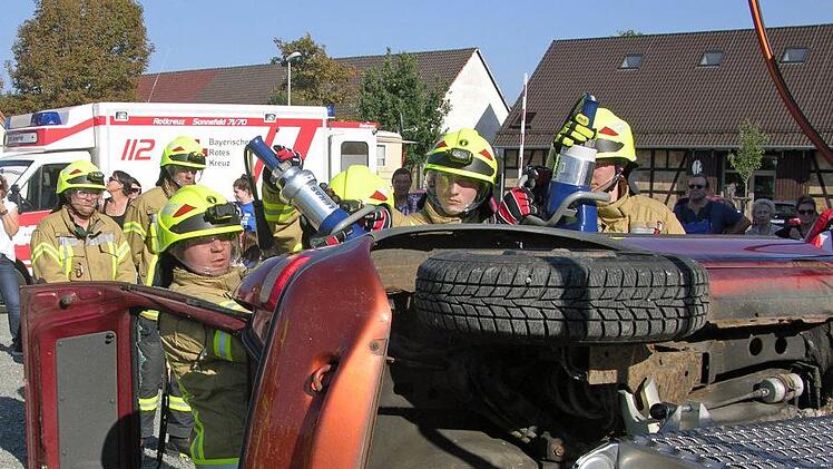 Unter Beachtung der eigenen Sicherheit trennen Feuerwehrleute mit einem Rettungsspreizer die Dachkonstruktion vom Fahrzeug. Foto: Klaus Oelzner
