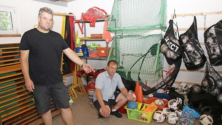 Vorsitzender Matthias Golle und Stellvertreter Stefan Bätz (von links), zeigen im Gerätelager wo der Rasentraktor stand, der zusammen mit anderem Equipment von Unbekannten gestohlen wurden. Foto: Michael Stelzner