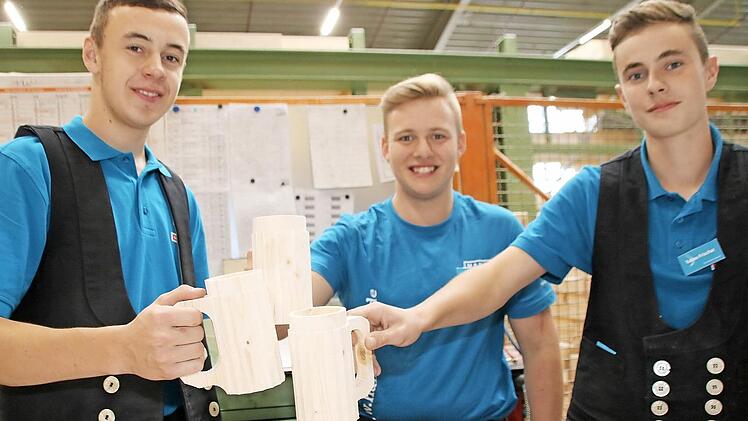 Die Azubis Markus Fischer, Johannes Müller und Tobias Frischat stoßen symbolisch auf das Handwerk an.