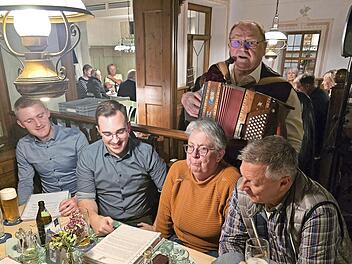 Robert Treuheit mit seiner Quetsche hinter einigen begeisterten Sängern, darunter auch Nico Kauper.