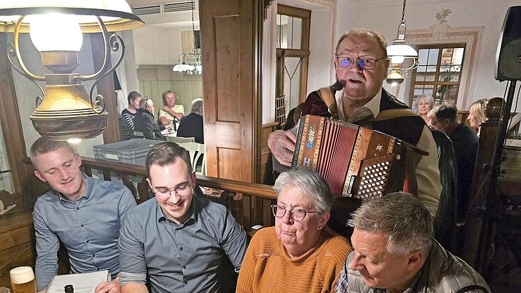 Robert Treuheit mit seiner Quetsche hinter einigen begeisterten Sängern, darunter auch Nico Kauper.