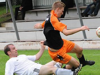 Greift auch mal zu rustikalen Mitteln: Hausens Spielertrainer Frank Dölling räumt Julian Seufert (TSV Aschach) und den Ball ab. Foto: Hopf