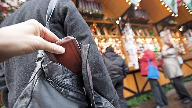 Im Gedr&auml;nge bei Weihnachtsm&auml;rkten haben Diebe leichtes Spiel. Daher sollte man Hand- oder Umh&auml;ngetaschen stets mit dem Verschluss zum K&ouml;rper tragen und Vorsicht walten lassen. Symbolbild: Frank Rumpenhorst/dpa