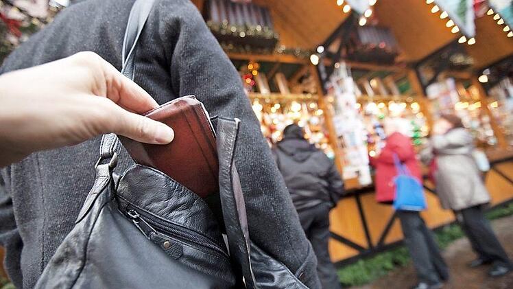 Im Gedränge bei Weihnachtsmärkten haben Diebe leichtes Spiel. Daher sollte man Hand- oder Umhängetaschen stets mit dem Verschluss zum Körper tragen und Vorsicht walten lassen. Symbolbild: Frank Rumpenhorst/dpa