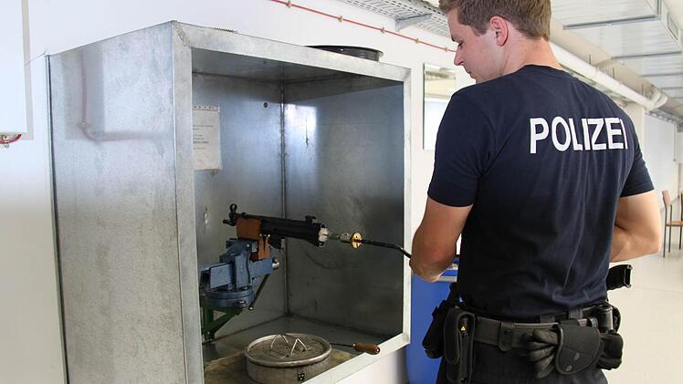 Mit einer Bürste werden Rückstände im Lauf der Maschinenpistole entfernt.