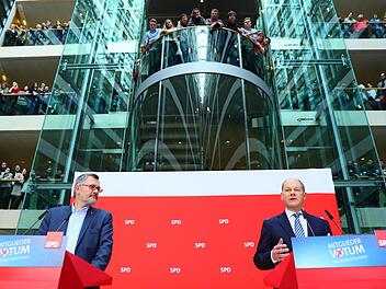 Der Chef der Mandatsprüfungs- und Zählkommission, Schatzmeister Dietmar Nietan (l) und Olaf Scholz, stellvertretender SPD-Vorsitzender und Erster Bürgermeister von Hamburg, verkünden das Ergebnis des SPD-Mitgliedervotums in der SPD-Zentrale. Foto: Michael Kappeler/dpa