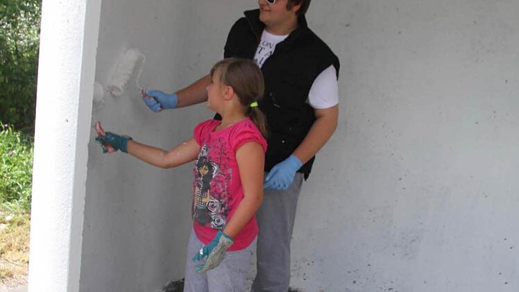 Jonas Gleich und Maya Hempfling sorgten für weiße Farbe in dem ausrangierten Buswartehäuschen. Foto: Sonja Adam