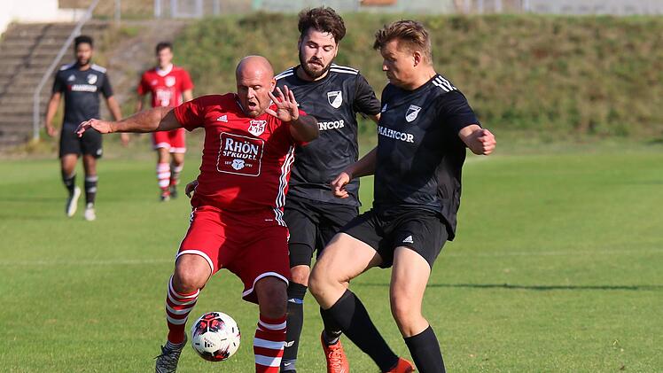 Jan Slawik (Mitte) ist aktuell Spieler und Co-Trainer beim SV Fatschenbrunn. In der kommenden Saison wird der 26-Jährige, der in dieser Szene zusammen mit Teamkollege Bastian Reitz (rechts) den Hermannsberger Alexander Frank (links) in die Mangel nimmt, die "Fatschis" gemeinsam mit Jakob Frank als Spielertrainerduo übernehmen.  Ralf Naumann