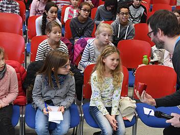 Jonas Wiese hält Bettina in der Kinder-Uni-Vorlesung "Morgen Kinder wird's was geben - von der Logistik des Nikolaus" eine Paprika hin. Gewünscht hat sie sich aber etwas anderes! Foto: Ronald Rinklef