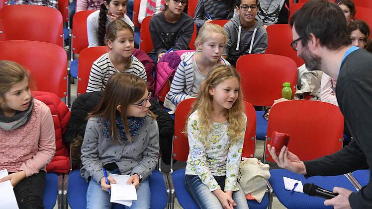 Jonas Wiese hält Bettina in der Kinder-Uni-Vorlesung "Morgen Kinder wird's was geben - von der Logistik des Nikolaus" eine Paprika hin. Gewünscht hat sie sich aber etwas anderes! Foto: Ronald Rinklef
