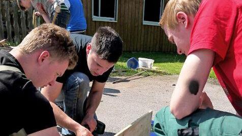Jugendliche freuen sich über fachkundige Unterstützung beim Renovieren ihres Treffs.