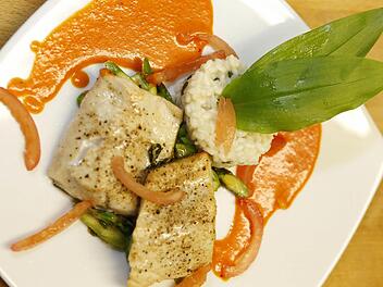 Lecker und leicht: Fränkisches Saiblingsfilet an Chili-Paprikasauce mit Bärlauch-Risotto und gebratenem grünen Spargel.  Foto: M. Hoch