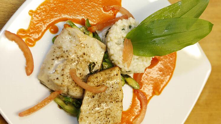 Lecker und leicht: Fränkisches Saiblingsfilet an Chili-Paprikasauce mit Bärlauch-Risotto und gebratenem grünen Spargel.  Foto: M. Hoch