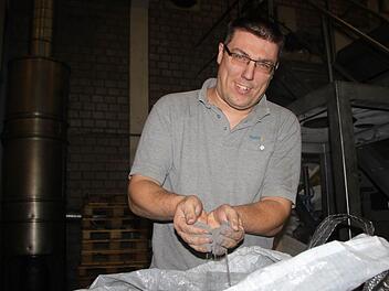 Marco Reinisch aus Bad Brückenau arbeitet seit 1996 im Metallwerk. Er zeigt, wie fein das Pulver ist, aus dem die Bauteile gepresst werden. Foto: Ulrike Müller