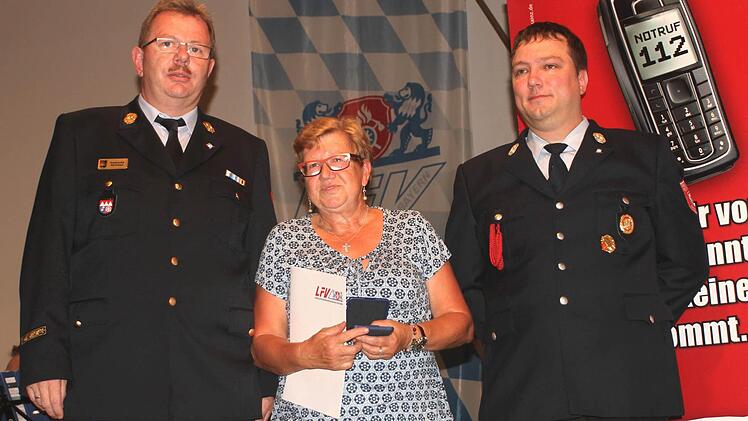 Für besondere Dienste wurde Dora Landgraf mit dem Bayerischen Ehrenabzeichen ausgestattet; links Kreisbrandrat Ralf Dressel und rechts Kommandant Daniel Holzmann.