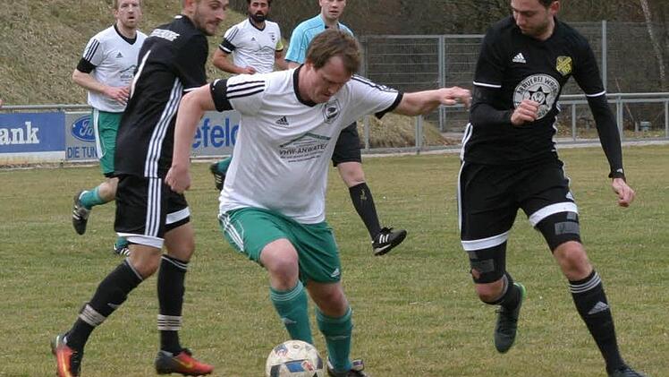 TV-Spielertrainer Johannes Fischer (Mitte), zweifacher Eberner Torschütze, setzt sich gegen seine Merkendorfer Gegenspieler Tobias Weber (rechts) und Benjamin Martin (links) durch.