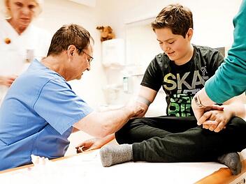 Auch bei seiner 250. Transfusion sticht ihn sein Arzt Dr. Glöckel. Seine Mutter hält ihm noch immer die Hand dabei. Foto: Lea Schreiber