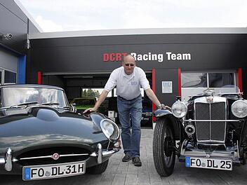 Heiko Dlugos mit zwei seiner Schmuckstücke: links ein Jaguar E-Type, Baujahr 1966, rechts ein MG J2 aus den 30-er Jahren.  Fotos. Andreas Oswald