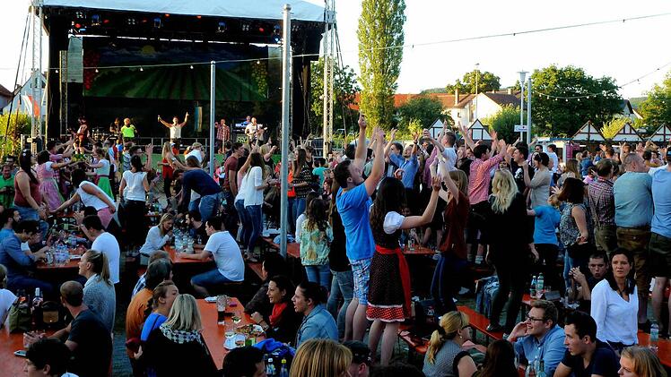 So kennt man das Weinfest in Sand: Es dauert nicht lange, und bald stehen die Besucher vor der Bühne begeistert auf Bänken und Tischen. Fotos: Alfons Beuerlein