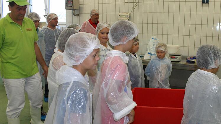 Gemeinsam schieben die Kids den Behälter mit dem Fleisch zum Fleischwolf. Foto: Janina Reuter