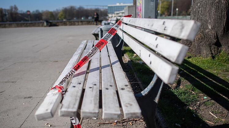 Mit Absperrband der Polizei ist eine Sitzbank am Maschsee in Hannover für Passanten gesperrt. Foto: Julian Stratenschulte / dpa