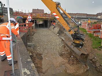 Der Moment, als der Güßbach in sein altes Flußbett geleitet wird: Seit Dienstag ist die Unterführung in Breitengüßbach unter der Bahnlinie (hinten) wieder offen. Foto: Ronald Rinklef