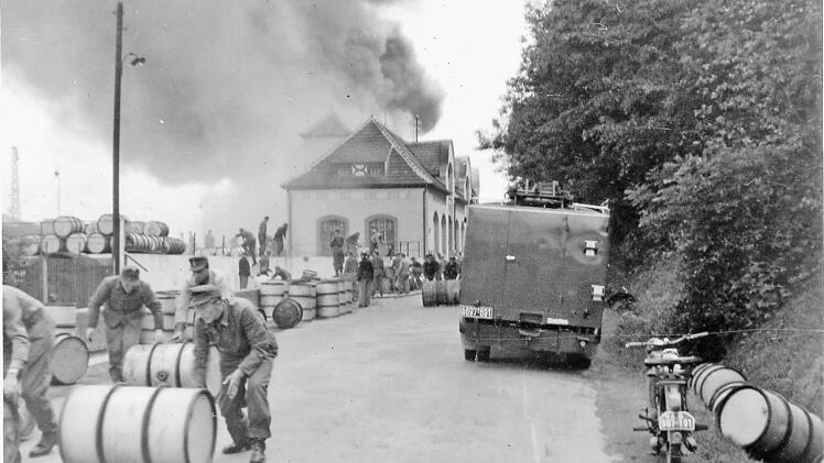 Eiligst brachten die Männer des Bundesgrenzschutzes volle Ölfässer in Sicherheit.   Repro: Gerd Fleischmann